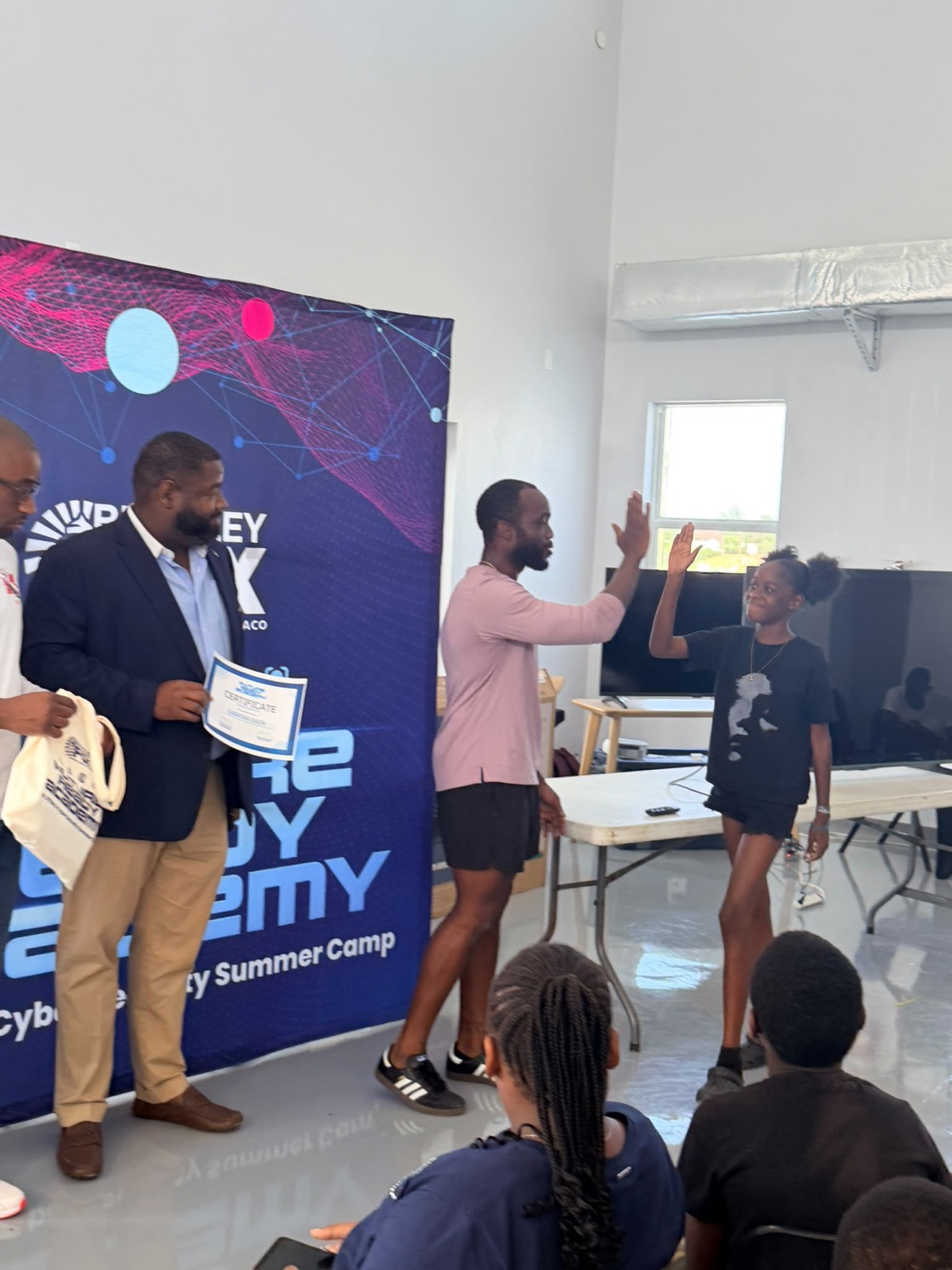 A camper receiving a certificate and a high-five at the closing showcase